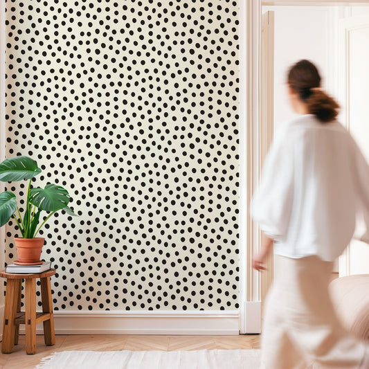 Minimalist room with Black Polka Dot Wallpaper and a woman walking by.