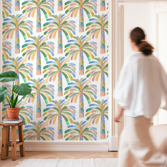 Woman standing in a room with colorful palm tree patterned wallpaper.