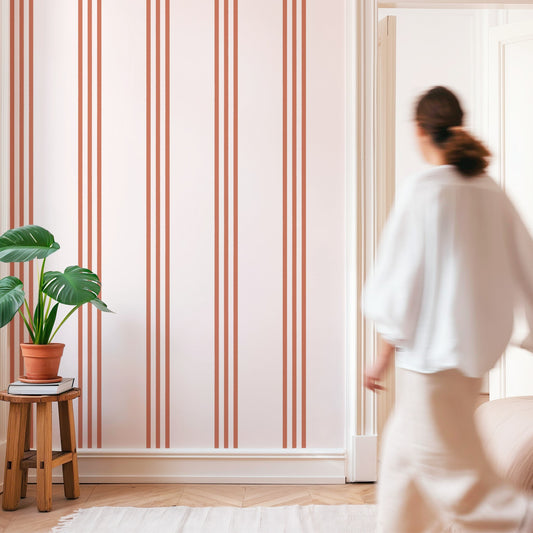 Minimalist room with Terracotta Boho Stripe Wallpaper and a woman walking by.