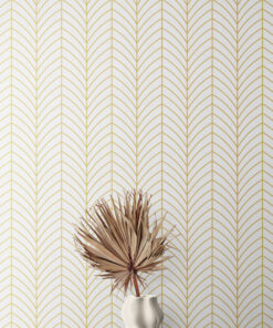 White and gold rounded chevron wallpaper on wall behind a modern vase with palm leaf sitting on table