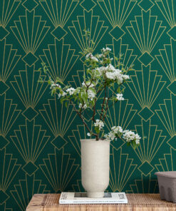 Green and gold art deco wallpaper behind side table with plant
