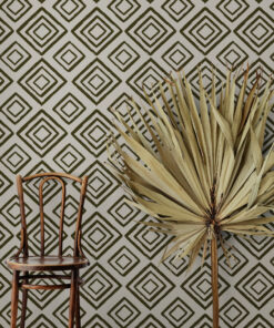 Pastel grey-brown wallpaper behind a chair and palm leaf