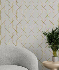 White and gold hexagon wallpaper on wall in living room with white armchairs and plant on side table
