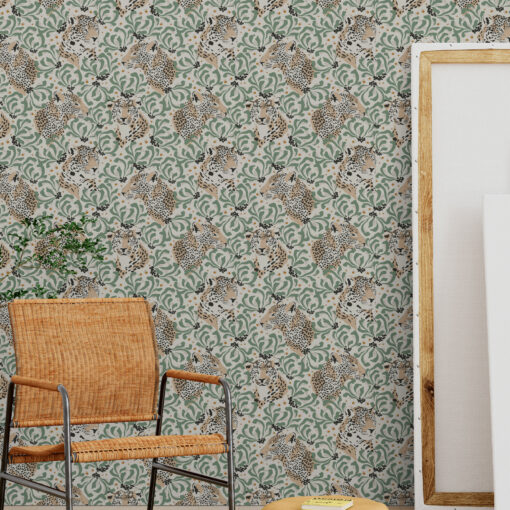 Green tropical cheetah wallpaper in studio room with orange chair and canvas panels