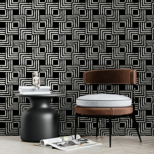 Black and white woven style wallpaper behind comfy chair and modern side table